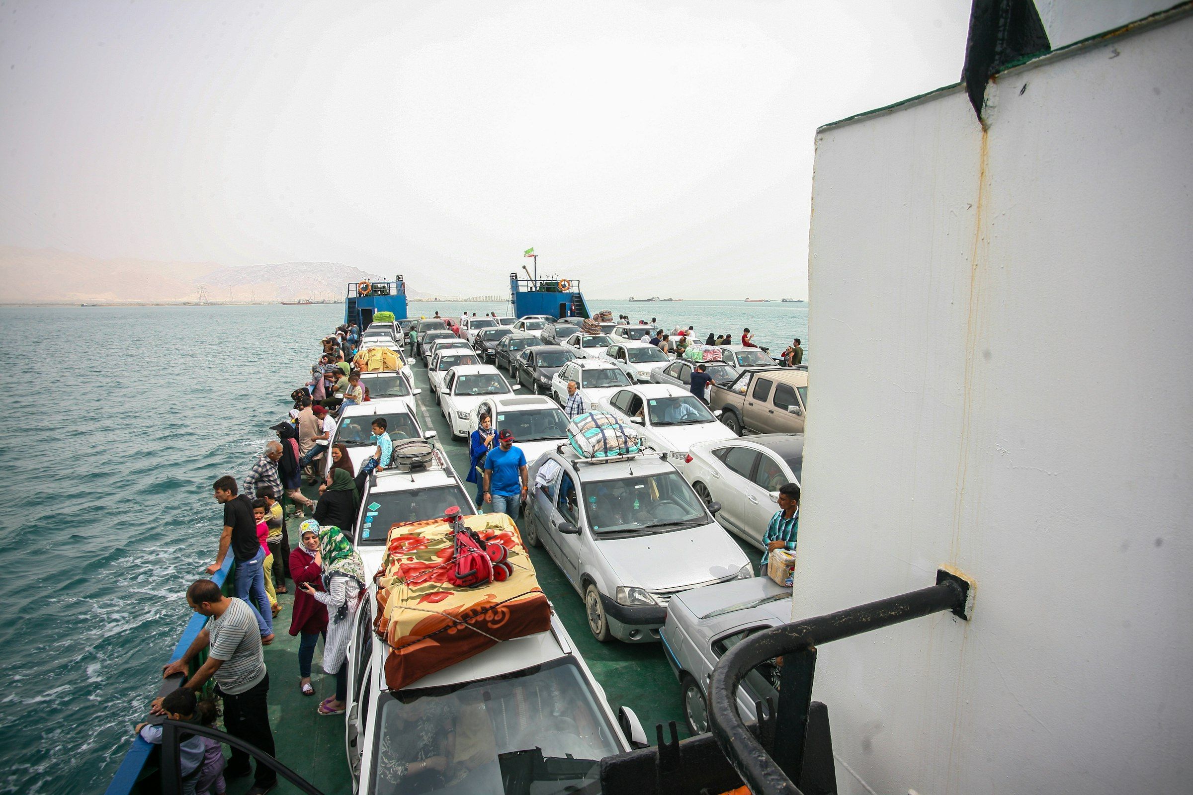 Cars and passengers on the open car deck of a ferry at sea