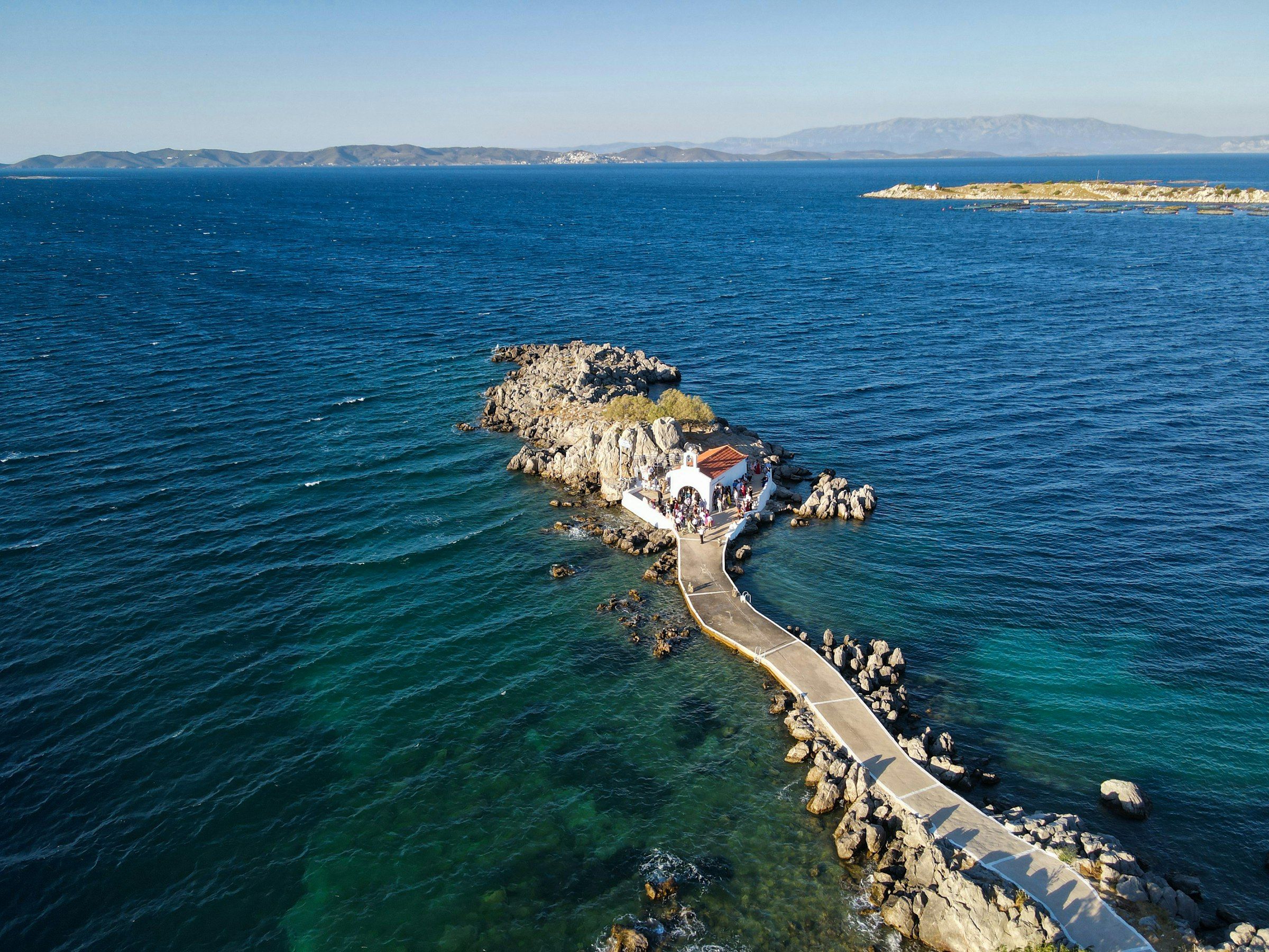 Luftaufnahme einer kleinen Kapelle und eines Stegs am Meer auf Chios
